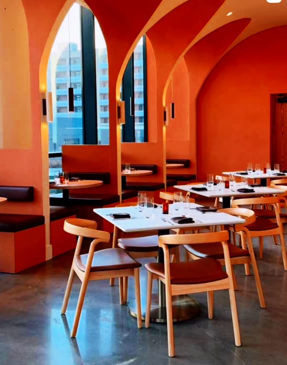 Emilia's terracotta dining room beneath tall arched windows, tables set for dinner